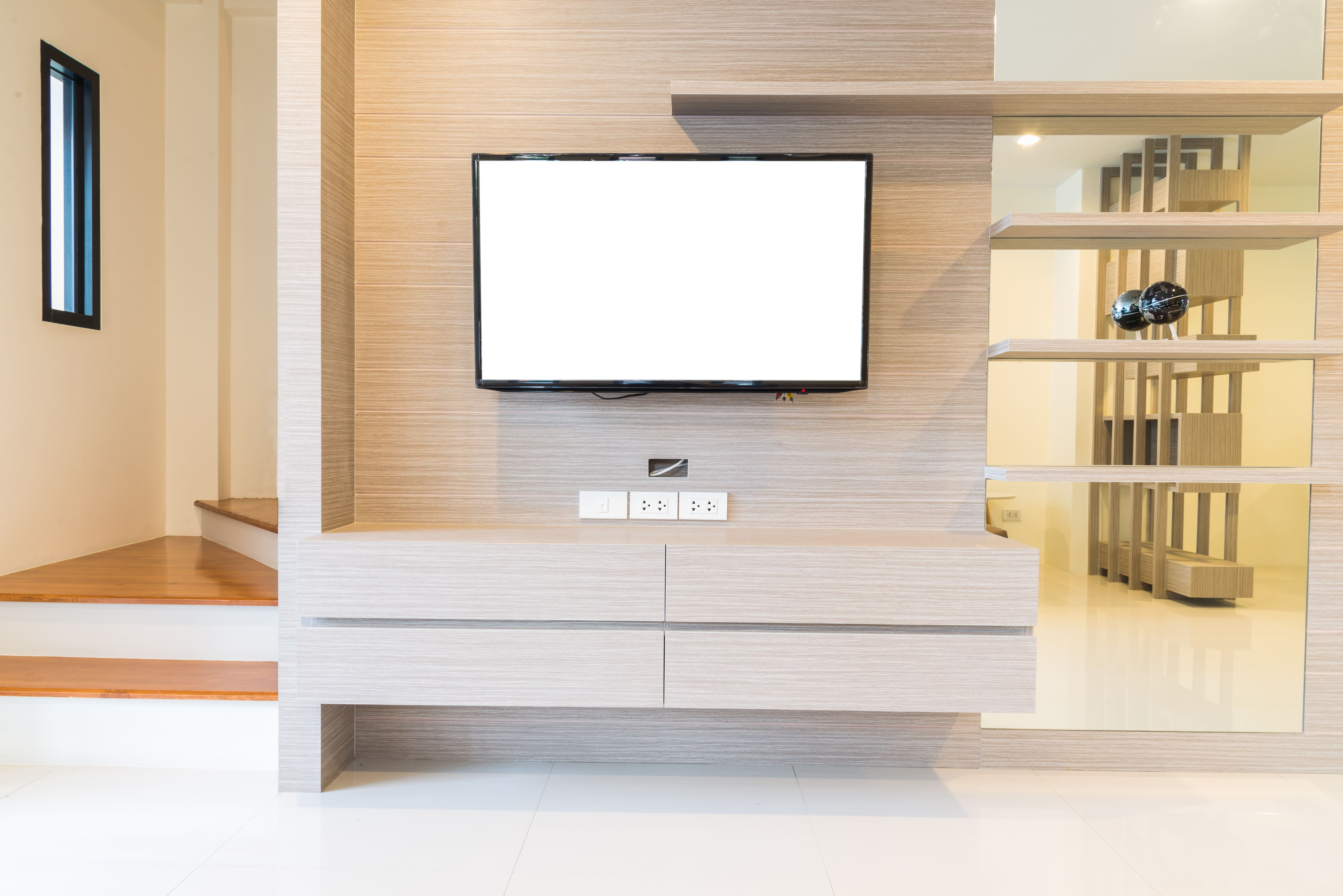 壁掛けテレビと収納棚、配線の見えないすっきりしたテレビまわりの空間